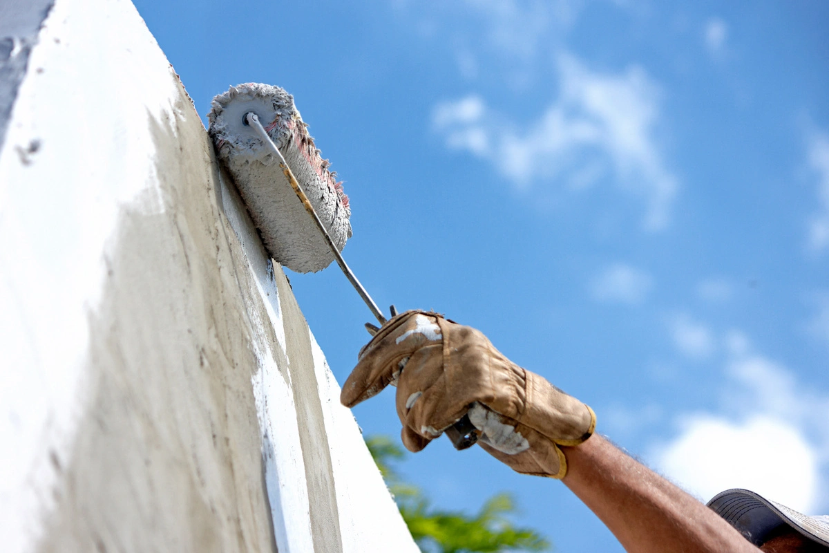 professionnel peignant un mur extérieur avec un rouleau